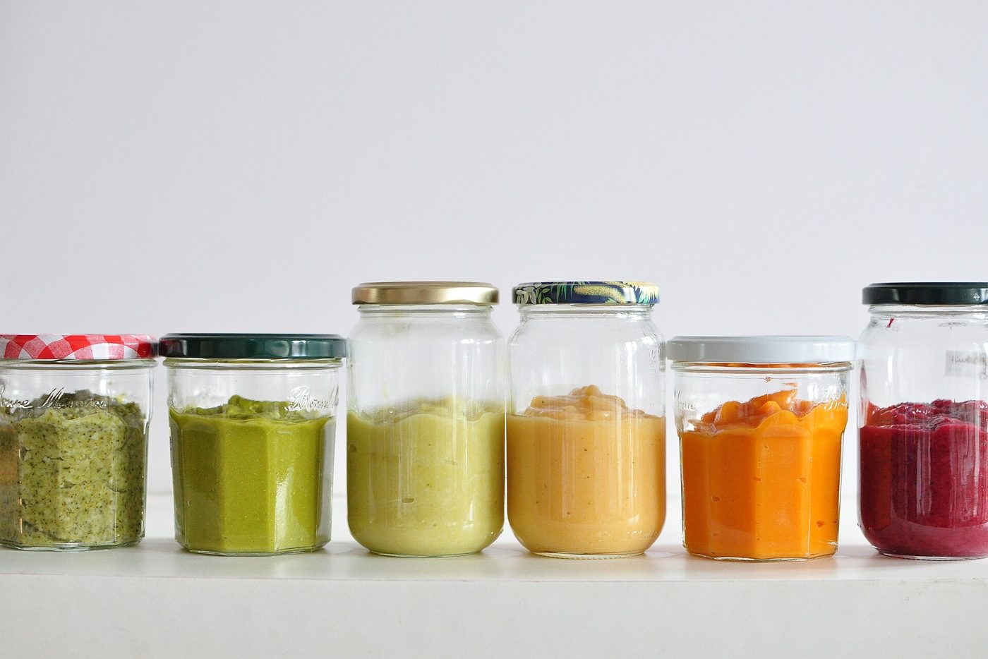 Glass jars of pureed vegetables and fruit