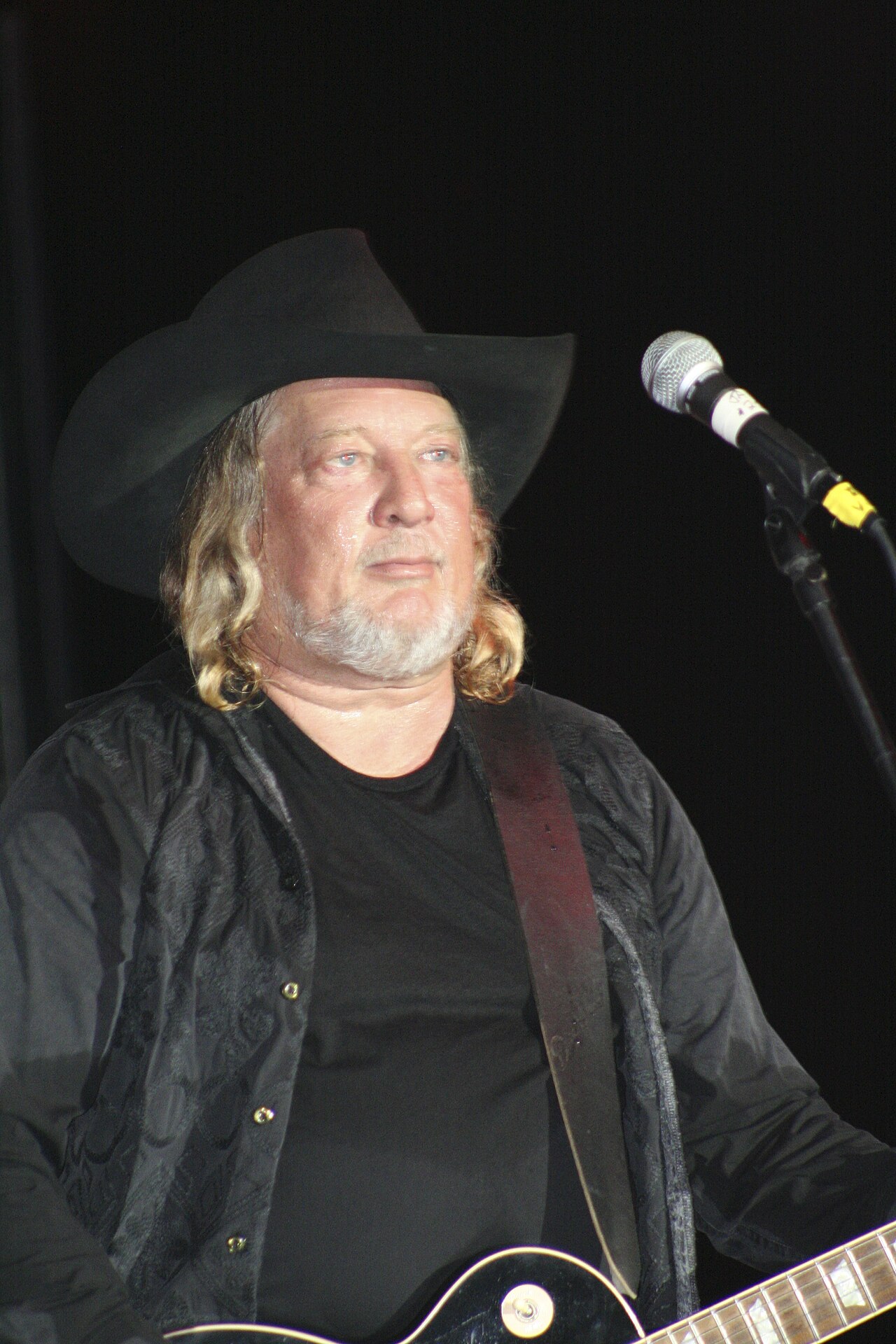 John Anderson performing on stage in a cowboy hat