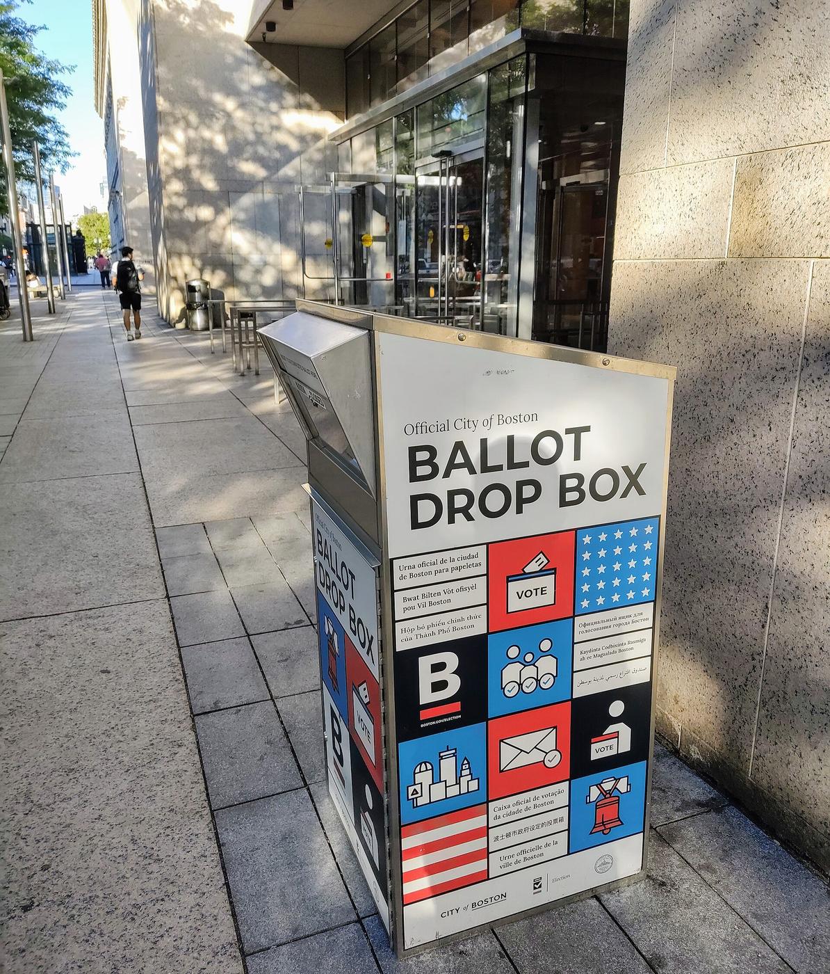 A white, blue, and red ballot drop box used for early voting in the city of Boston, Massachusetts.