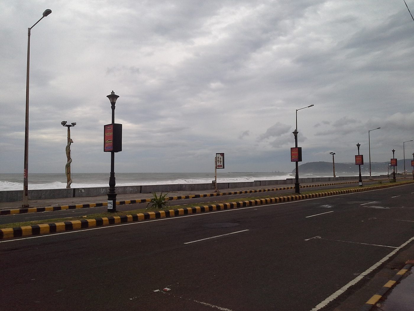Storm damage along a coastal road after a prior Andhra cyclone
