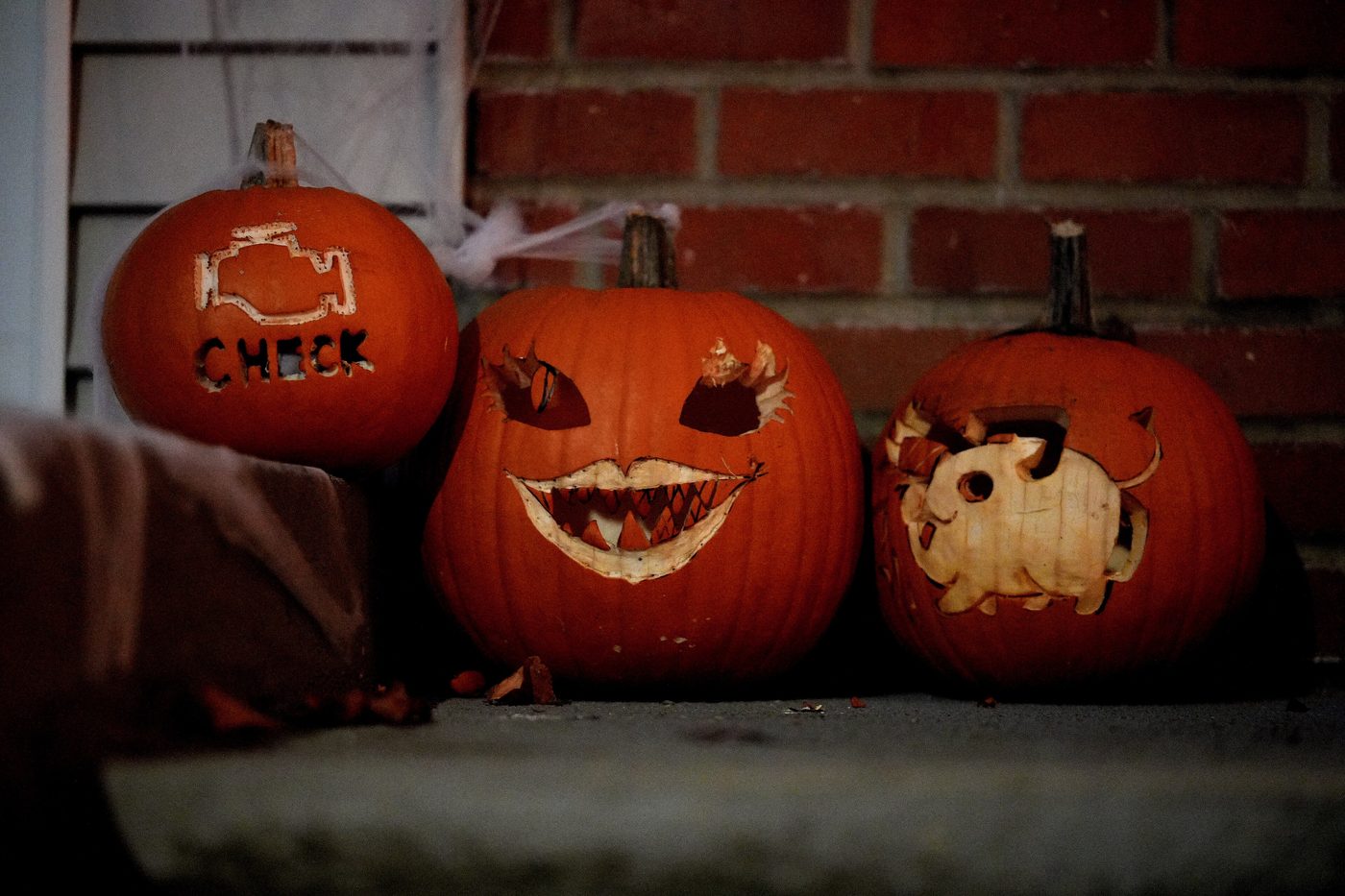 Three carved jack-o'-lanterns on a porch step