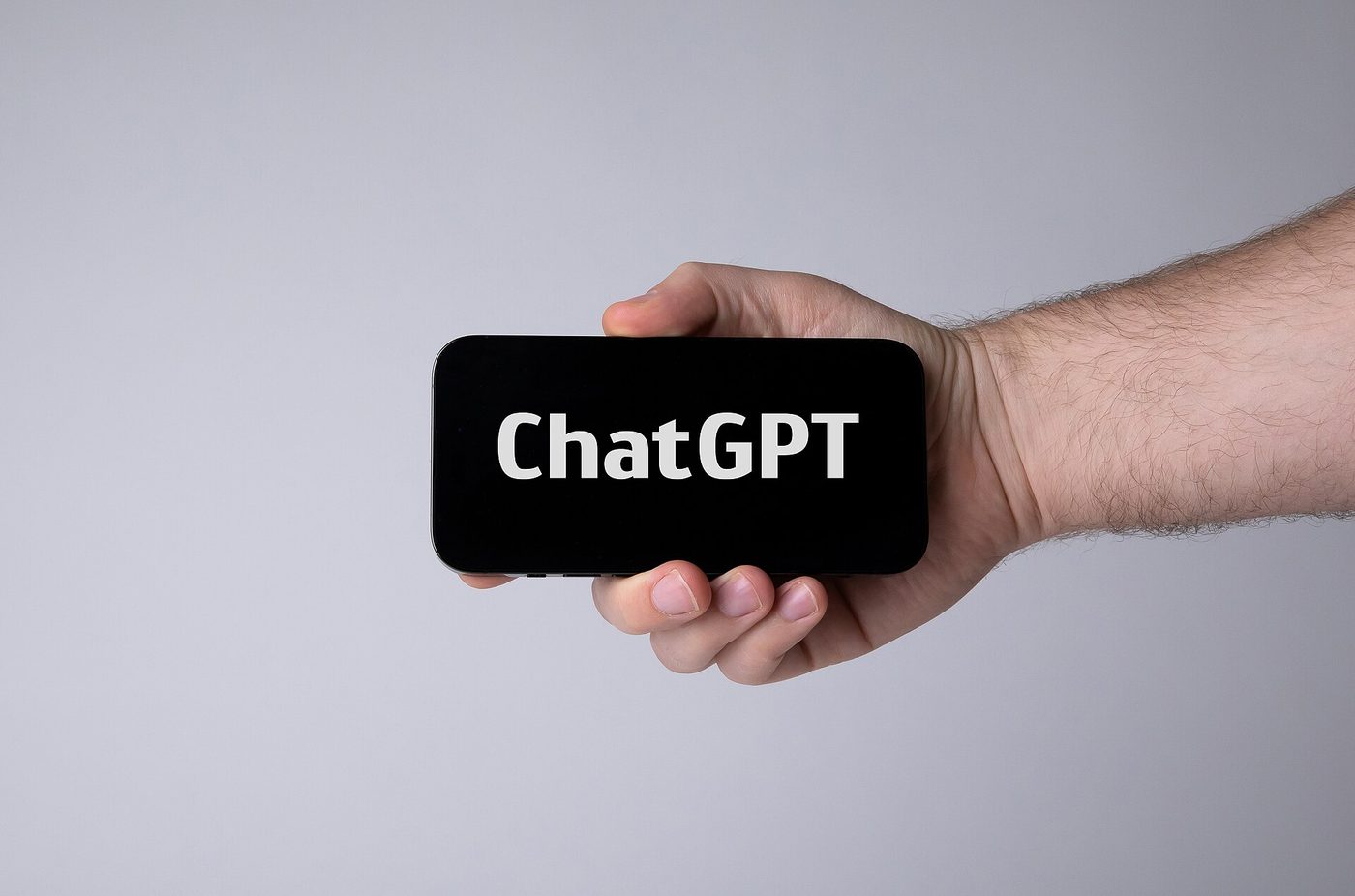 A hand holding a smartphone with ChatGPT open