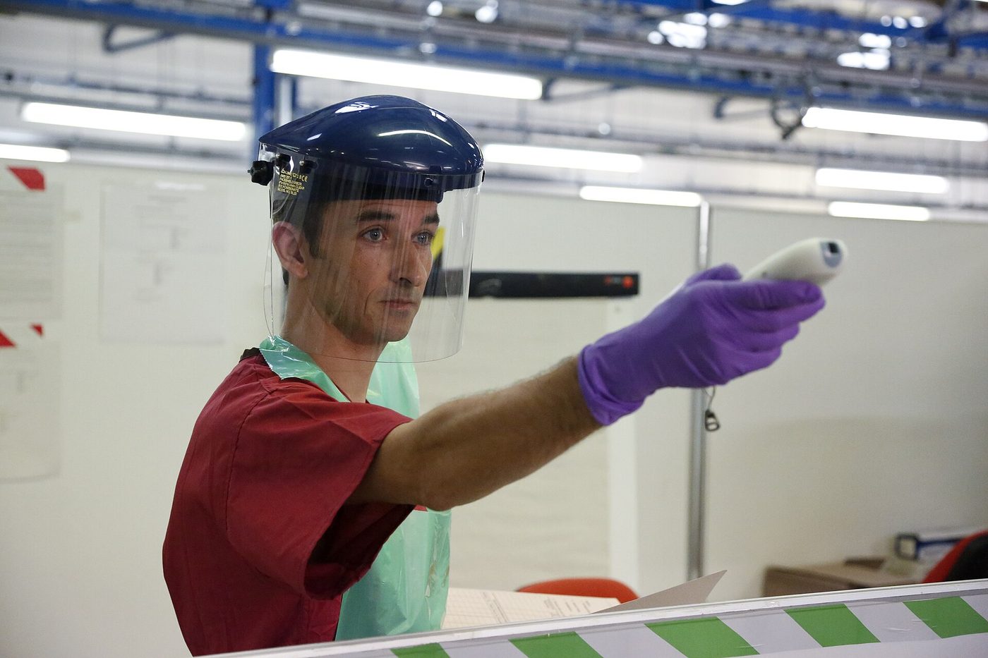 A health worker takes a temperature during an Ebola outbreak