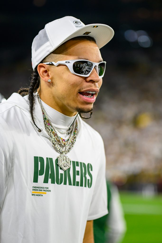 Packers receiver Christian Watson in a Packers T-shirt and cap on the field