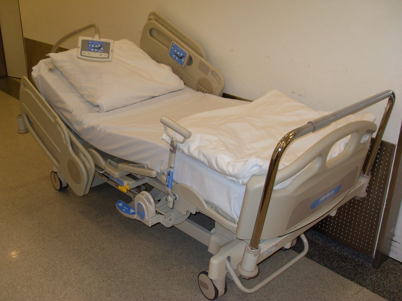An electric hospital bed with side rails in a hospital room