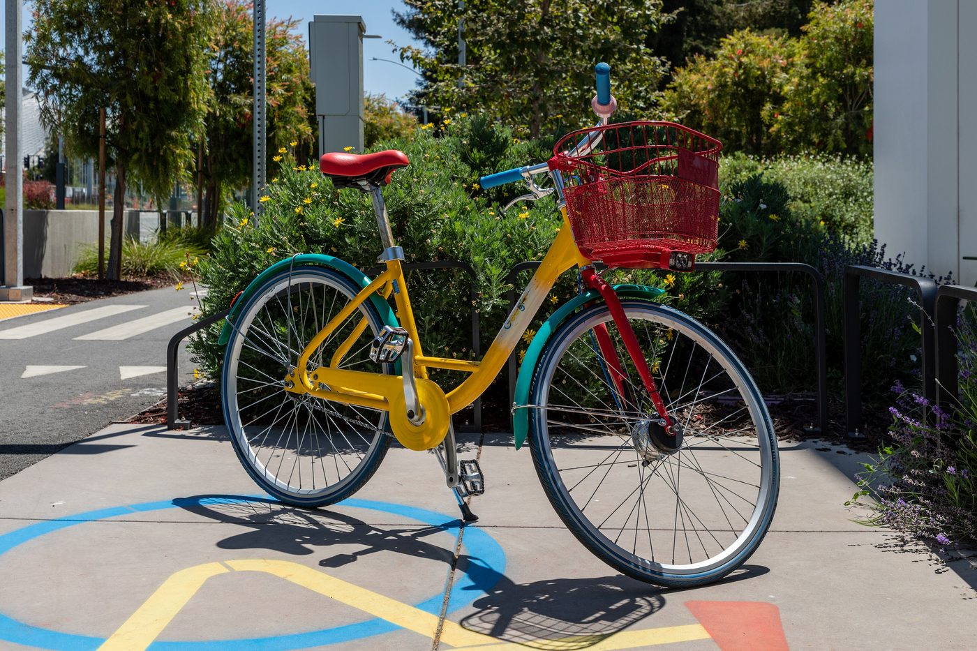 A yellow, red and green Google bicycle parked on a street in Mountain View, California