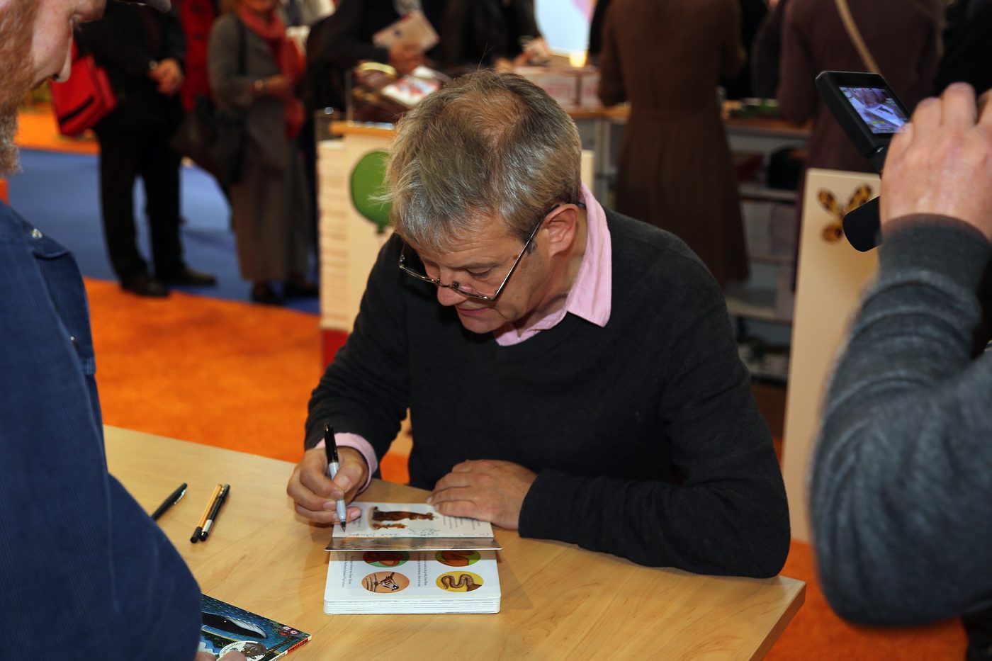 Illustrator Axel Scheffler signs books at a table at the Frankfurt Book Fair