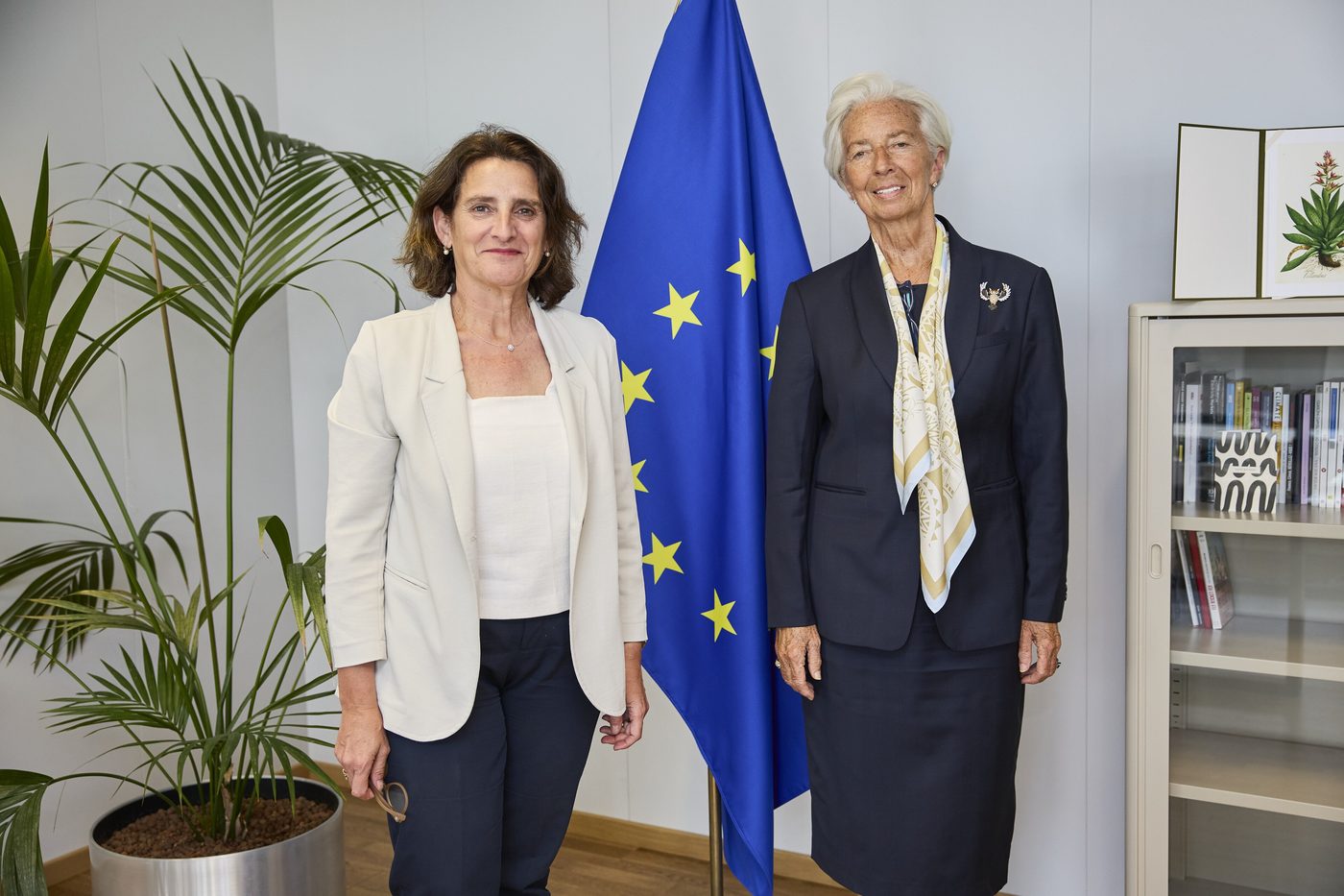 Christine Lagarde, right, stands with Teresa Ribera beside an EU flag