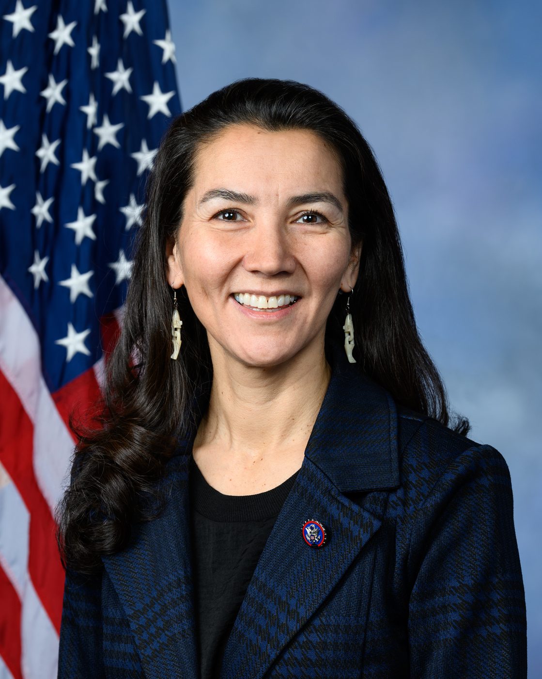 Official portrait of Mary Peltola in front of an American flag