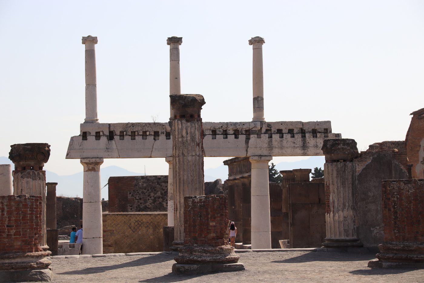 Columns and brick walls among the ruins of Pompeii