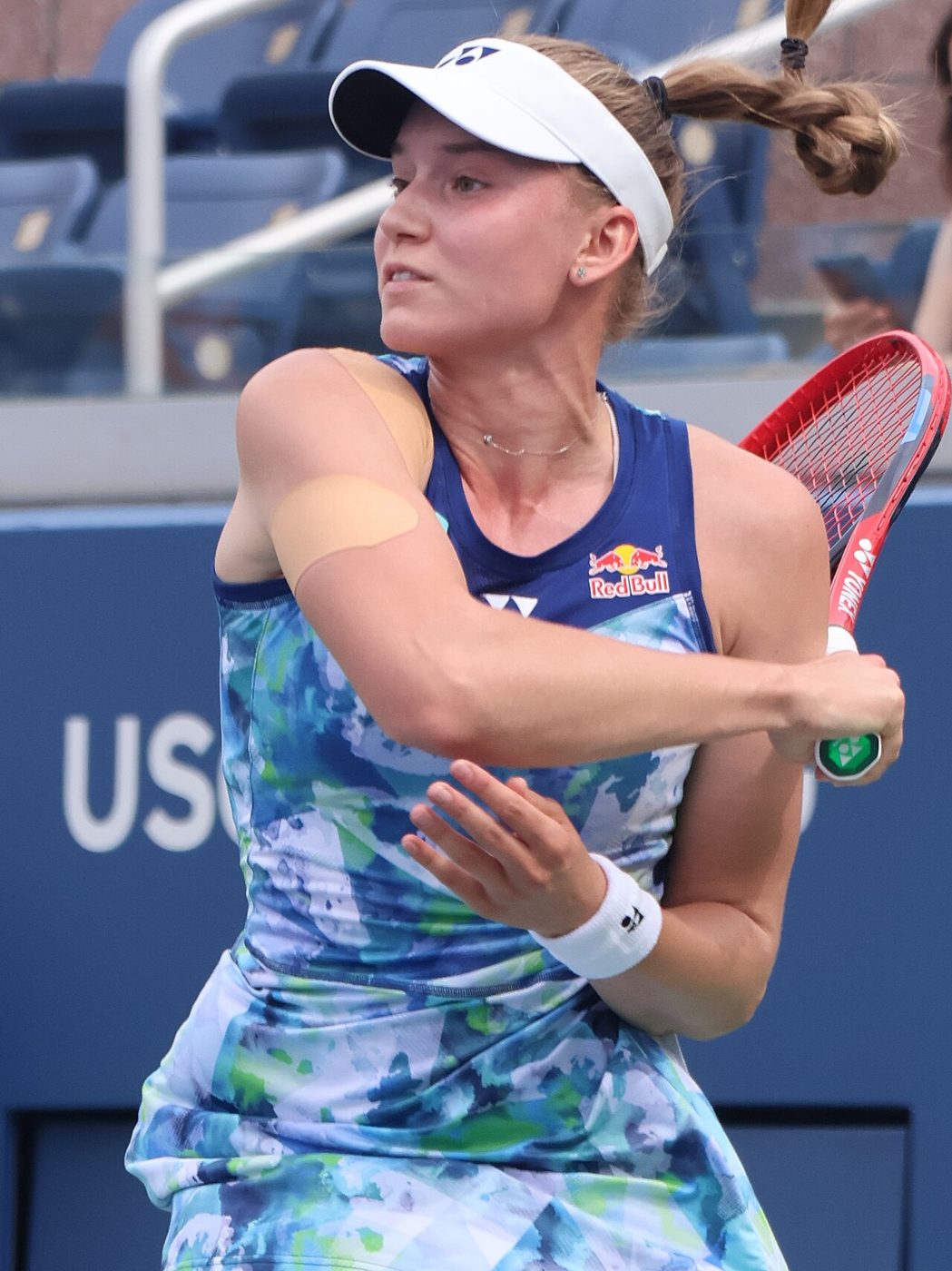 Elena Rybakina hits a forehand on a blue hard court