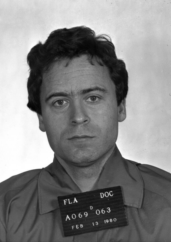 Black-and-white mug shot of Ted Bundy holding a booking placard