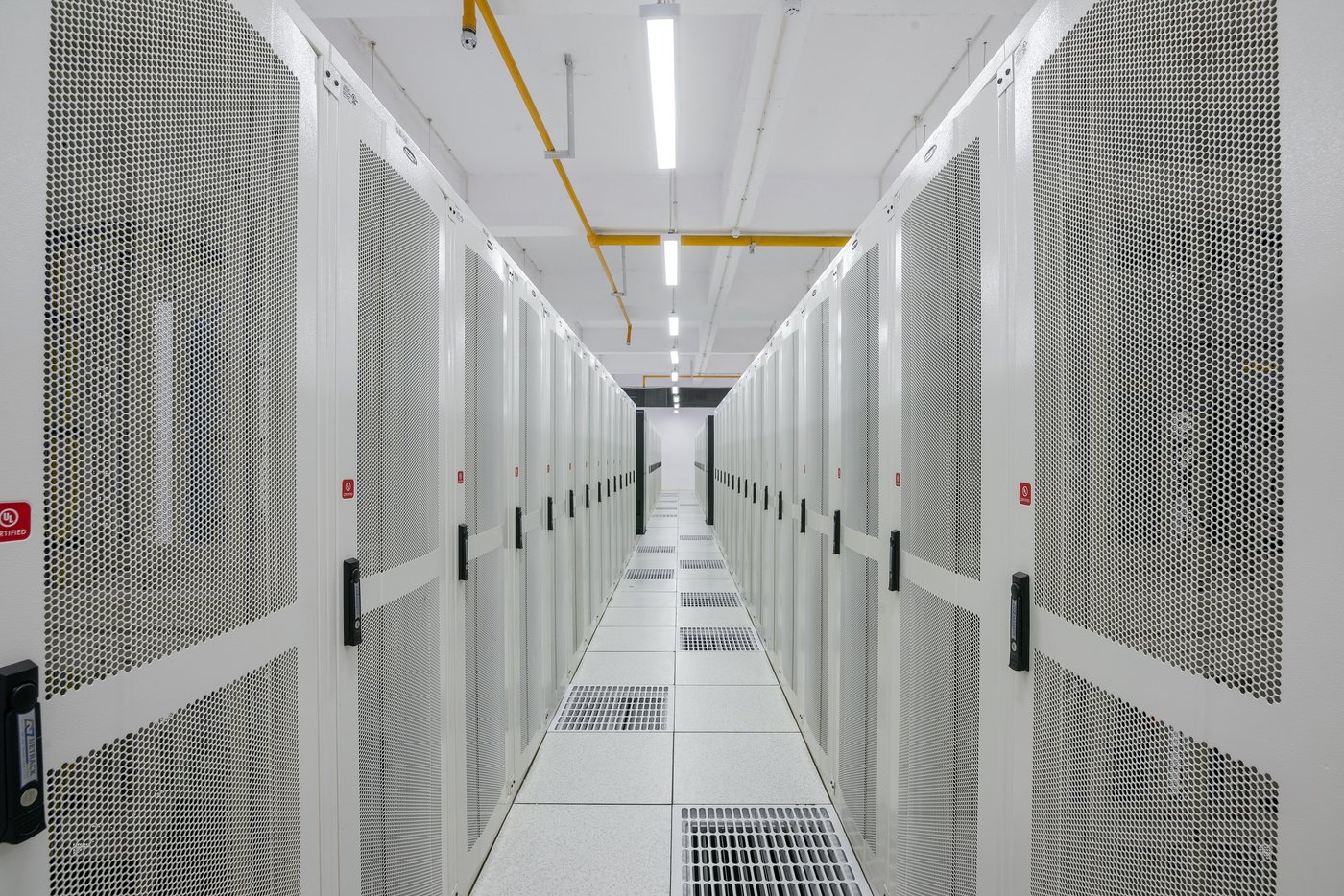 Rows of black server racks in a brightly lit data center