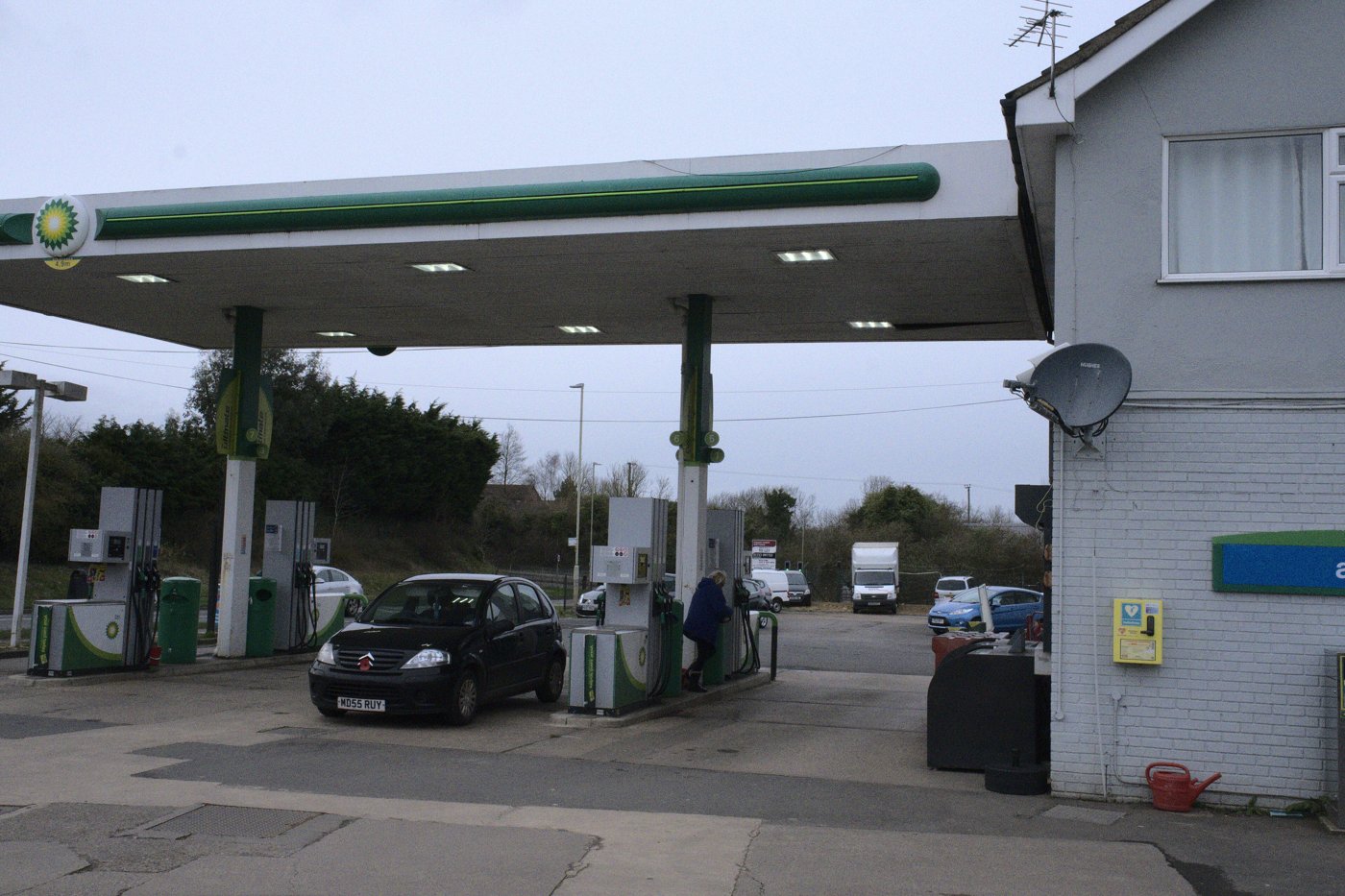 Cars at the pumps of a BP petrol station under a green canopy