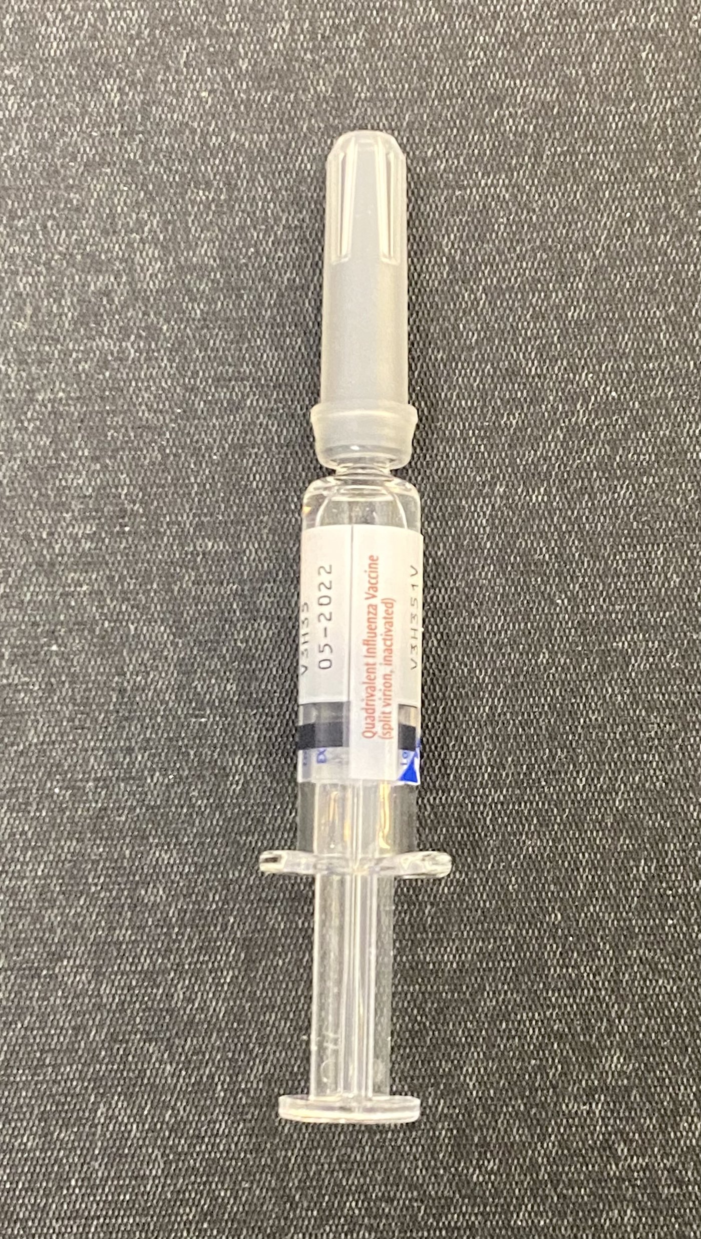 A flu vaccine in a prefilled syringe on a white background