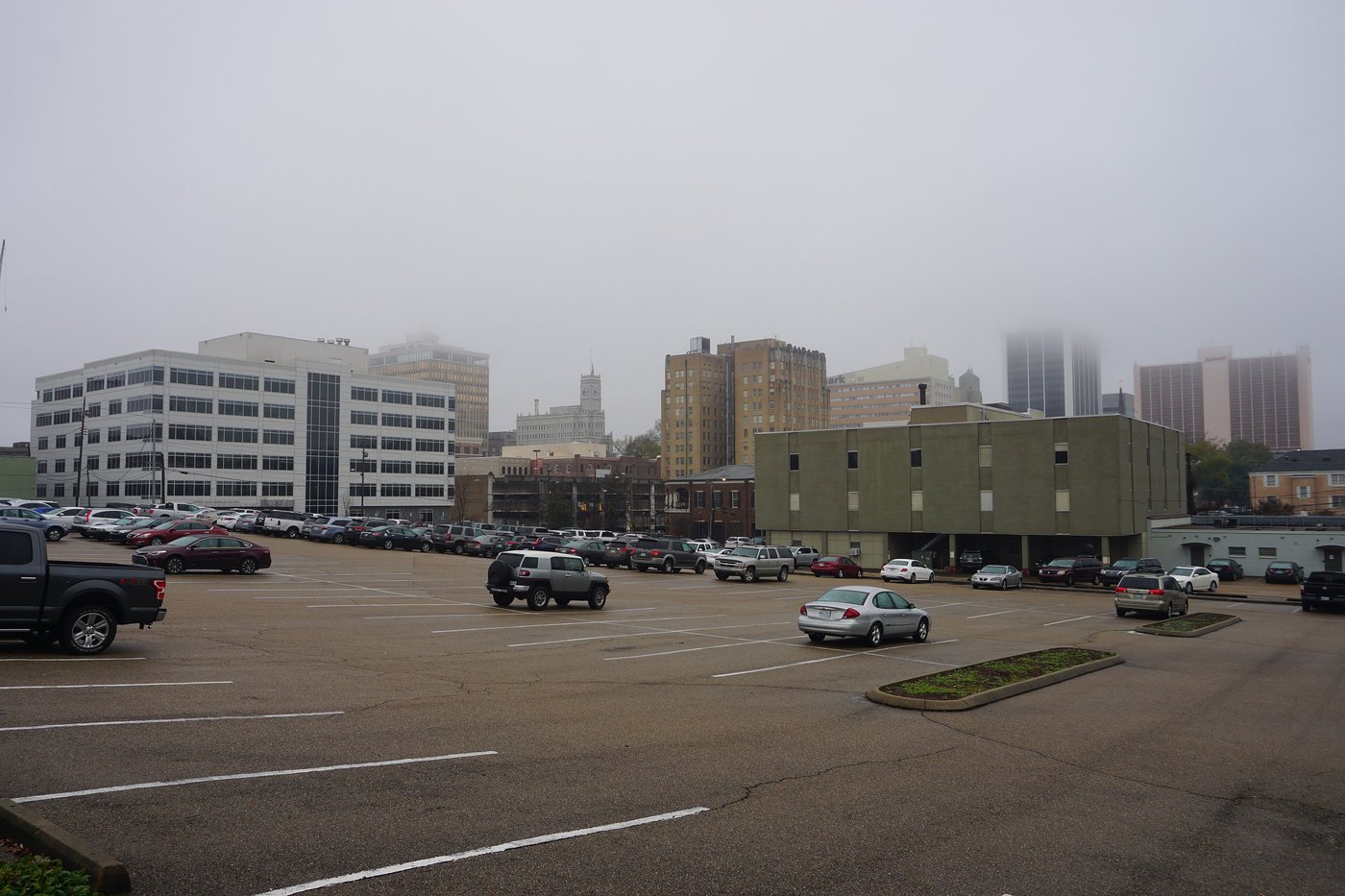 The downtown skyline of Jackson, Mississippi, on a hazy day, seen across a parking lot