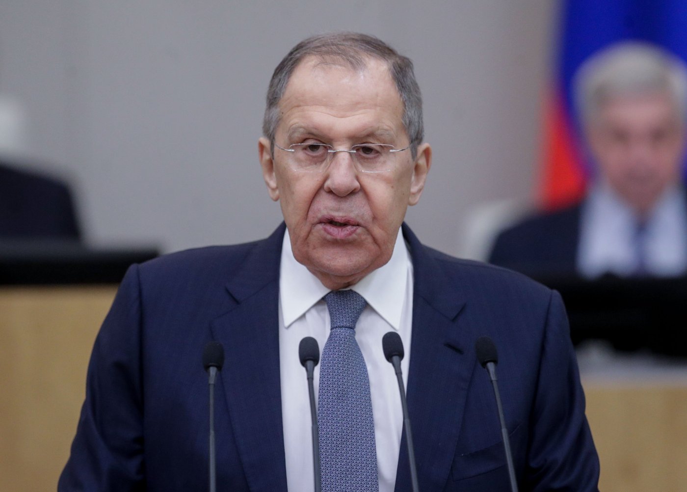 Russian Foreign Minister Sergei Lavrov speaks at a lectern with microphones