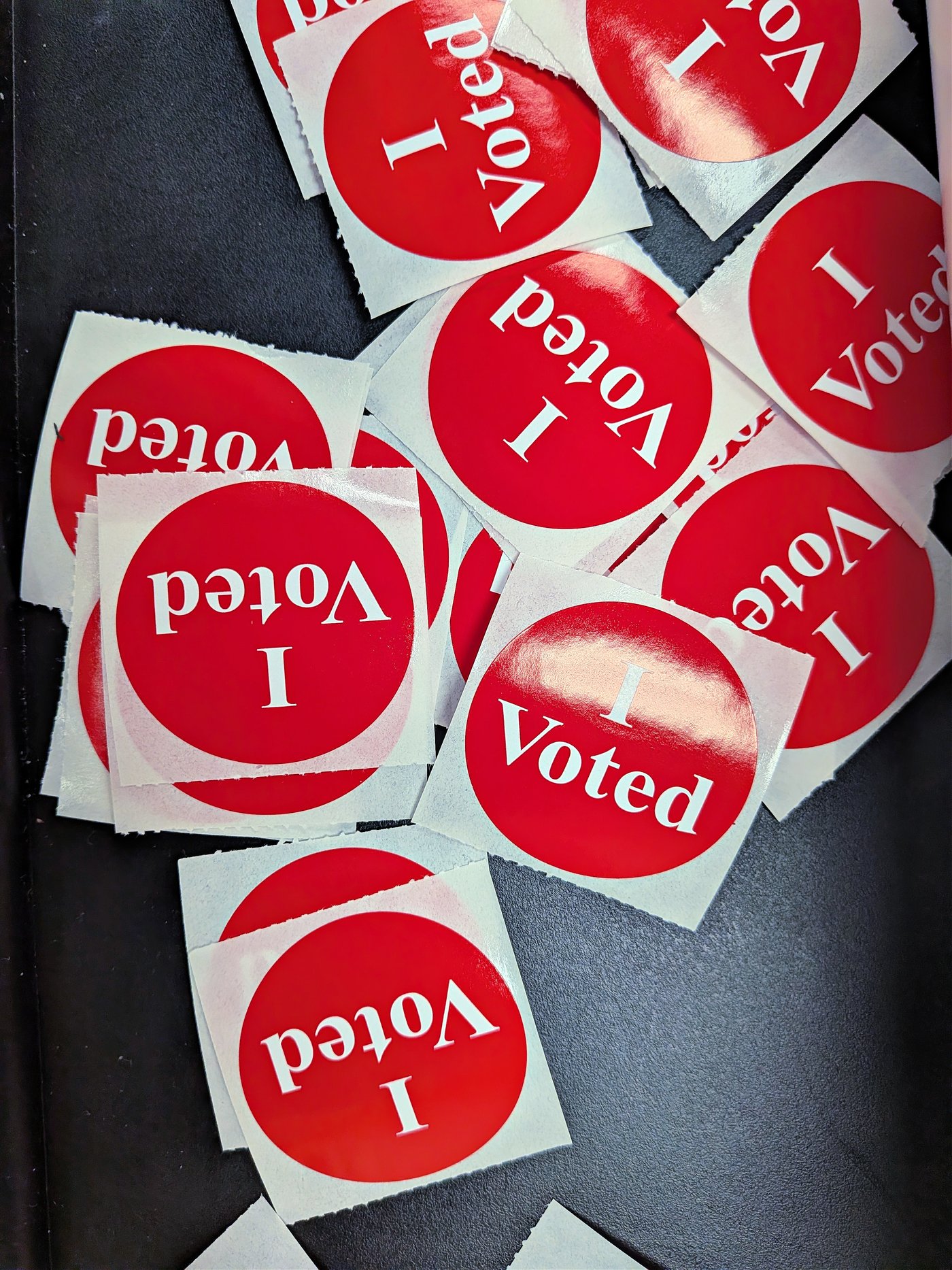 A pile of red and white I Voted stickers