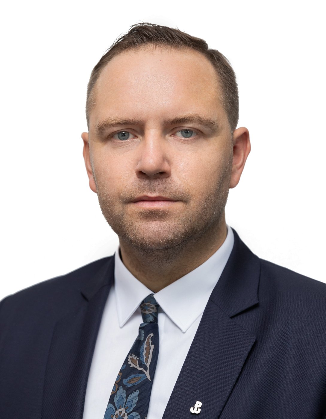 Polish President Karol Nawrocki in a dark suit against a white background